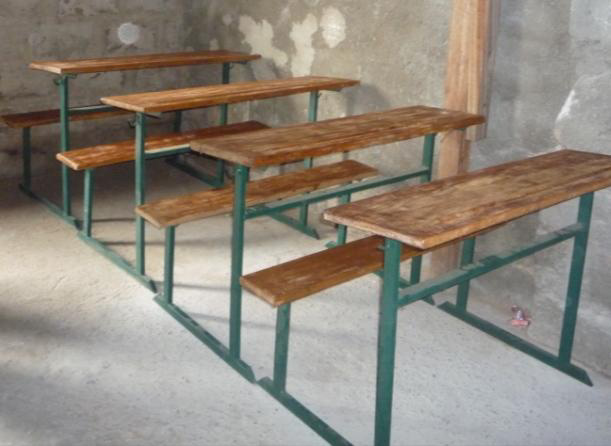 Foto de un aula con viejos bancos de madera