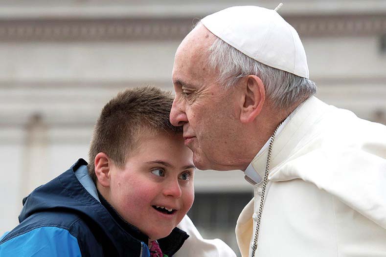 El Papa Francisco besa a un niño con síndrome de down